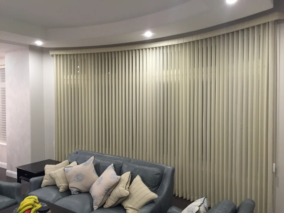 Sheer Vertical around a curved window wall behind a sofa in Vancouver
